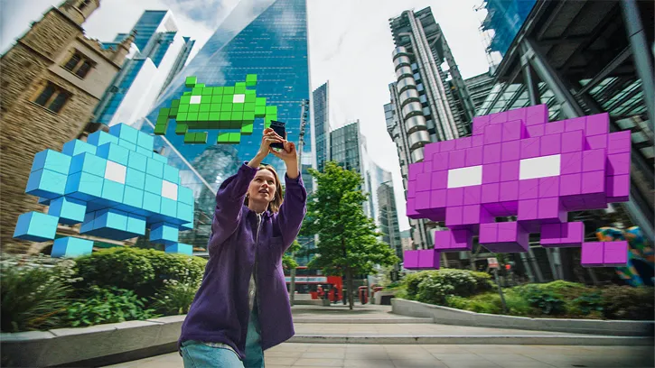 Weibliche Spielerin, die London vor 3D-Weltraum-Invasoren in Augmented Reality schützt