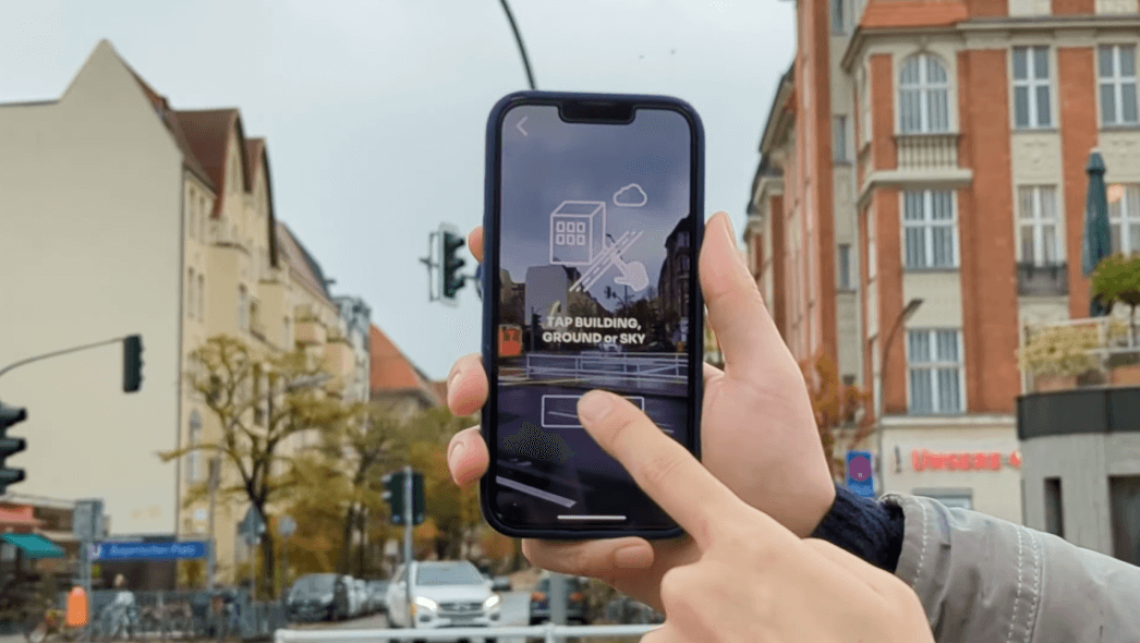Application mobile invitant l'utilisateur à appuyer sur le bâtiment, le sol ou le ciel à l'écran
