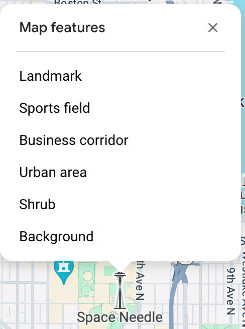 Pemeriksa peta terbuka di atas Space Needle dan mencantumkan enam Fitur Peta pada titik klik tersebut: tempat terkenal, lapangan olahraga, koridor bisnis, area perkotaan, semak semak, dan latar belakang.