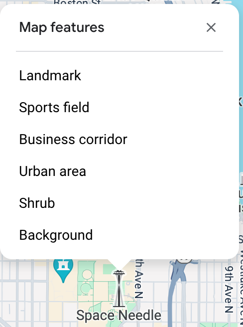 Space Needle&#39;ın üzerinde harita denetleyici açılır ve tıklanan noktada altı harita özelliği listelenir: önemli yer, spor sahası, iş bölgesi, kentsel alan, çalı ve arka plan.